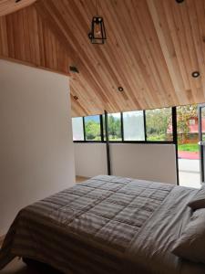 a bedroom with a large bed in a room with windows at Casa Francis Oxapampa in Oxapampa