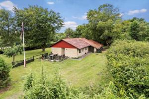 Una casa vieja con techo rojo en un campo en 30073-Ulfborg-Grastensborgvej-35, en Sønder Nissum