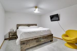 a bedroom with a bed and a yellow chair at 6 Mi to Barr Lake Apt with Hot Tub Access! in Brighton