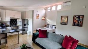 a living room with a couch and a kitchen at Luxury Studio in Fourways in Sandton