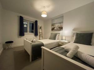 a bedroom with two beds and a couch at Hawksbill 3 Bed Detached house with private parking in Peterborough