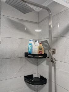 a bathroom with a shelf with three bottles of soap at Villa Nicole in Katarrákhion +42 photos