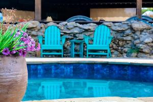 three blue chairs sitting next to a swimming pool at MeMaws Country Cabin in Pipe Creek +17 photos