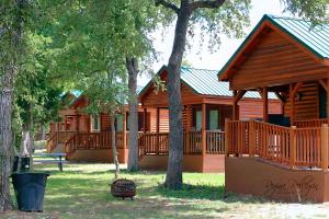 a large wooden cabin with a porch and trees at MeMaws Country Cabin in Pipe Creek