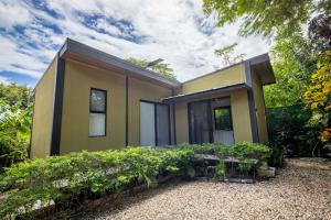 a small yellow house with some bushes at Casa Playa Avellanas in Playa Avellana