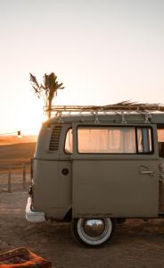 an old van parked in a parking lot with a palm tree at Amazigh van Agafay in Oumnas +37 photos