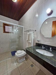 モンテ・ヴェルデにあるChalés Caminho das Pedrasのトイレ、洗面台、鏡のあるバスルーム