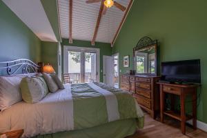a bedroom with a bed and a television and a dresser at Echota Ridge Boulders in Banner Elk +40 photos