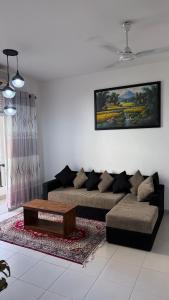 a living room with a couch and a coffee table at Cozy Clifford Homagama in Homagama