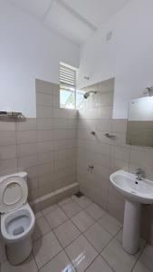 a bathroom with a toilet and a sink at Cozy Clifford Homagama in Homagama