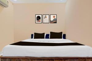 een slaapkamer met een groot bed met vier foto's aan de muur bij OYO TRIPAL SSS HOTEL in Pānchgaon