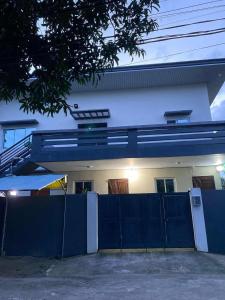 ein Haus mit einem blauen Zaun davor in der Unterkunft chez moi, ma maison in Oogong