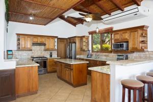 a large kitchen with wooden cabinets and a ceiling at Casa Colorados in Tola