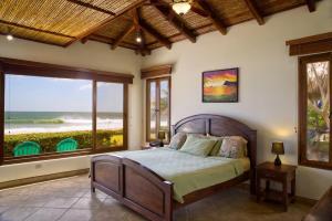 a bedroom with a bed with a view of the ocean at Casa Colorados in Tola