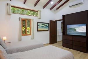 a bedroom with two beds and a flat screen tv at Casa Colorados in Tola