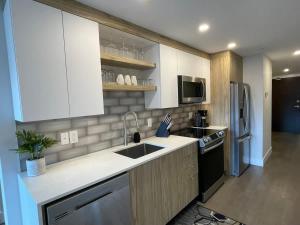 a kitchen with a sink and a refrigerator at Downtown bright cozy & modern 1 Bedroom in Halifax