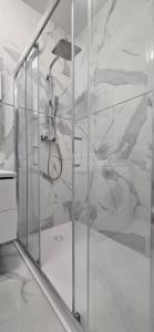 a shower in a bathroom with a marble wall at Apartament Srebrny Quick Park Oława in Oława +7 photos
