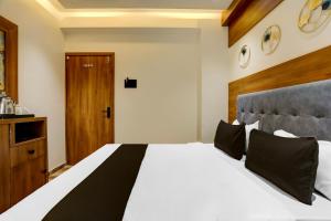 拉杰果德Hotel O The Infinity的卧室配有白色大床和木制床头板