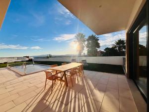 a table and chairs on a patio with a view at Al Casa Branca in Lourinhã
