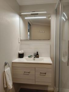 a bathroom with a sink and a mirror at Private Rotorua Hideaway - Pet Friendly BB with Electric Heating in Mourea +69 photos