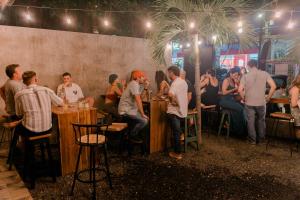 a group of people sitting at tables in a bar at Refugio Surf Lodge in Tamarindo +52 photos