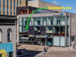 a building with a green arrow pointing to a downtown city view at Modern City View 1BR Apartment with Office - free parking in Appleton +2 photos