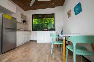 a kitchen with a table and green chairs at Casa Playa Avellanas in Playa Avellana +15 photos
