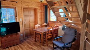 チスナにあるMagiczne Bieszczady - Krzywe 24のテーブルとテレビのあるダイニングルーム