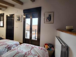 a bedroom with a bed and a door with a balcony at La casa del patio in Ágreda