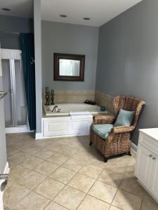 a bathroom with a bath tub and a chair at The Inn, Occano Arnold Palmer Golf, Luxury 4 Bedroom 