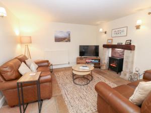 a living room with leather furniture and a fireplace at Nick Jone in Feetham