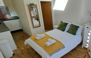 a bedroom with a bed with two slippers on it at Ty Heulwen Studio in St. Davids