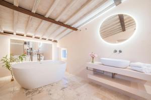 a bathroom with a large tub and a mirror at Dimora Segreta in Pienza
