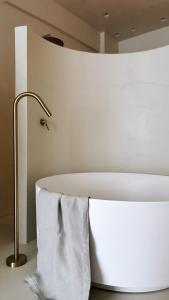 a white bath tub in a room with a lamp at âme casa in Mesochórion +13 photos