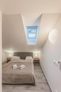 a bedroom with a bed and a skylight at Moderní podkrovní byt 2KK u náměstí s klimatizací in Hradec Králové