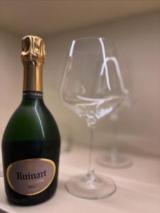 a green bottle of wine next to a wine glass at âme casa in Mesochórion