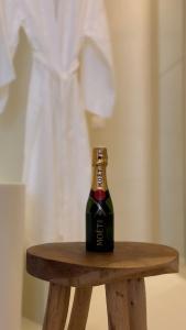 a bottle of beer sitting on a wooden stool at âme casa in Mesochórion