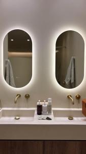 a bathroom with two sinks and two mirrors at âme casa in Mesochórion +13 photos