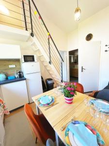 ein Esszimmer mit Tisch und eine Küche in der Unterkunft FLYHOME en mezzanine pour famille - 8 min à pied de Gare - Mi Disney & Paris in Noisiel