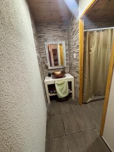 a small bathroom with a mirror and a sink at casa con vista 360 a las sierras y pileta in Bialet Massé