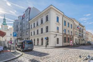 a van parked in front of a building on a street at Moderní podkrovní byt 2KK u náměstí s klimatizací in Hradec Králové
