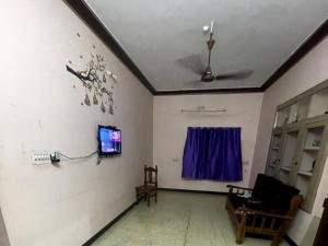 a living room with a ceiling with a tv on a wall at The Ultimate stay in Puducherry