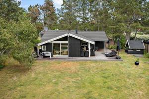 a small black house with a large deck at SL070-Slagelse-Snerlevej-2 in Slagelse