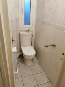 a bathroom with a white toilet with a window at 2 chambres dans Appartement cozy in Rodez