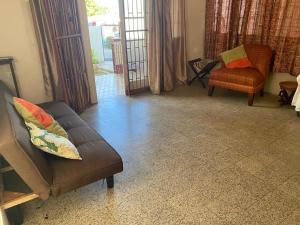 a living room with a couch and a chair at charming 1 bedroom house in Port-of-Spain +2 photos