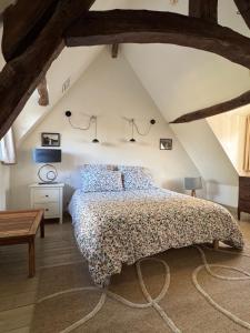 a bedroom with a large bed in a attic at La Chapelle de Monet - Logis Roses Rouges in Bois-Jérôme-Saint-Ouen