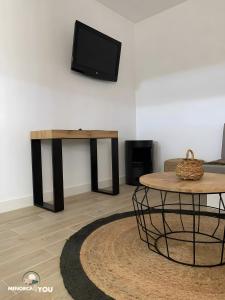 een woonkamer met een tafel en een tv bij Nathan in Son Bou +19 foto's