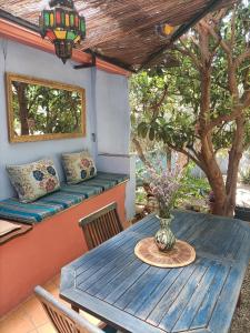 a blue table and chairs on a porch with a bench at Aguas Calmas in Nigüelas