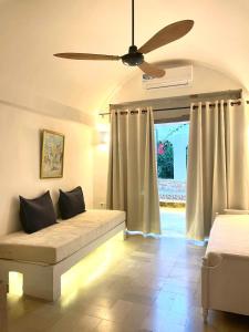 a living room with a couch and a ceiling fan at Casa Dea - bungalow Mykonos in Hammamet Sud +89 photos