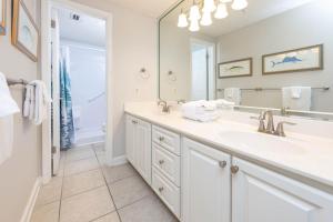 Phoenix X 1412 condo في شاطئ أورانج: حمام أبيض مع حوض ومرآة